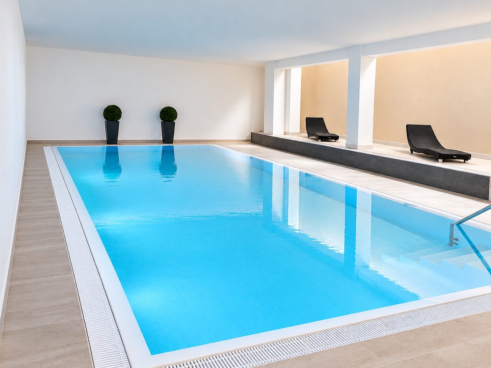 Das Schwimmbecken im Hotel zum L&ouml;wen in M&ouml;rfelden-Walldorf, ruhig beleuchtet, mit Liegen am Beckenrand